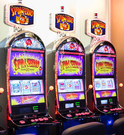 Three Spinferno tournament slot machines displayed together on a casino floor