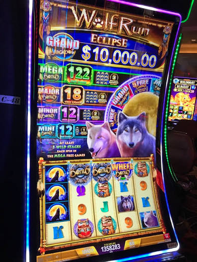 Wolf Run Eclipse casino cabinet featuring wolves, a moon, bonus features, and jackpot displays